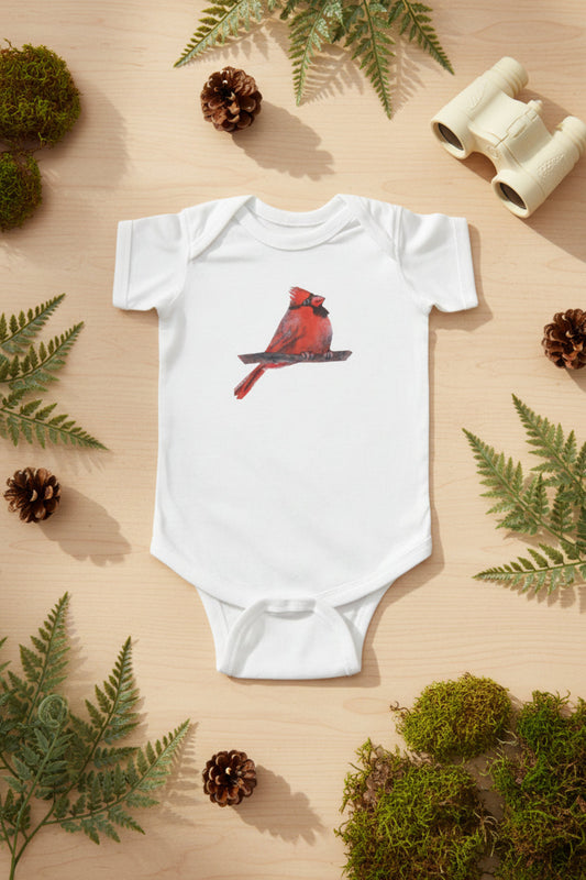 White baby onesie with a red cardinal bird design on a nature background
