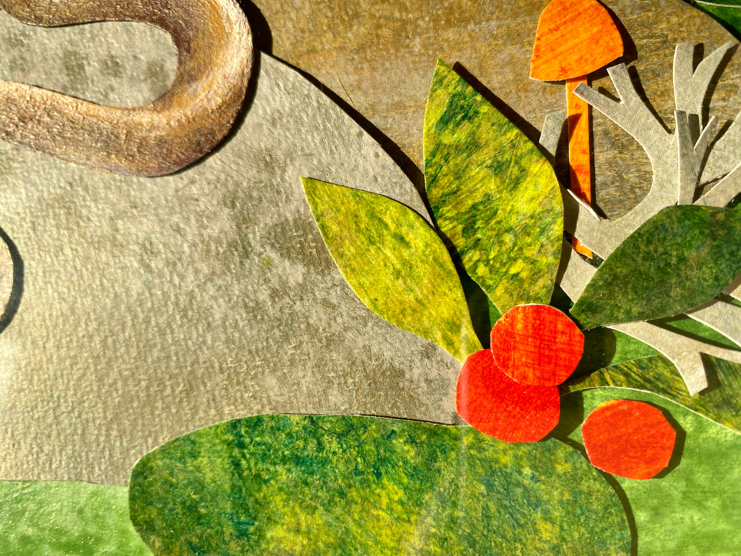 Close-up of a textured surface with green leaves, red berries, and an orange object.