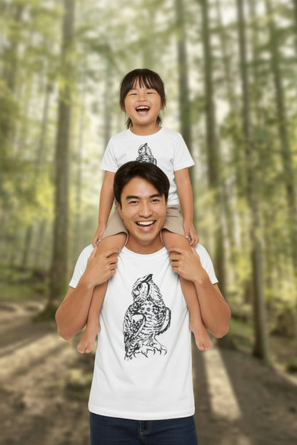 Man wearing a white t-shirt with a black graphic design in a forest setting