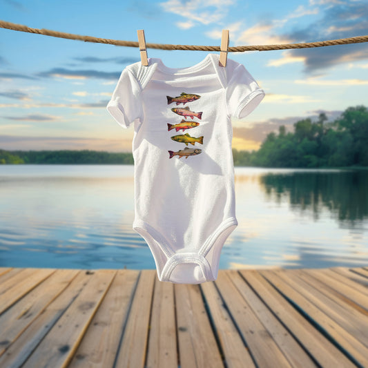 White baby onesie with fish design hanging on a clothesline over a lake.